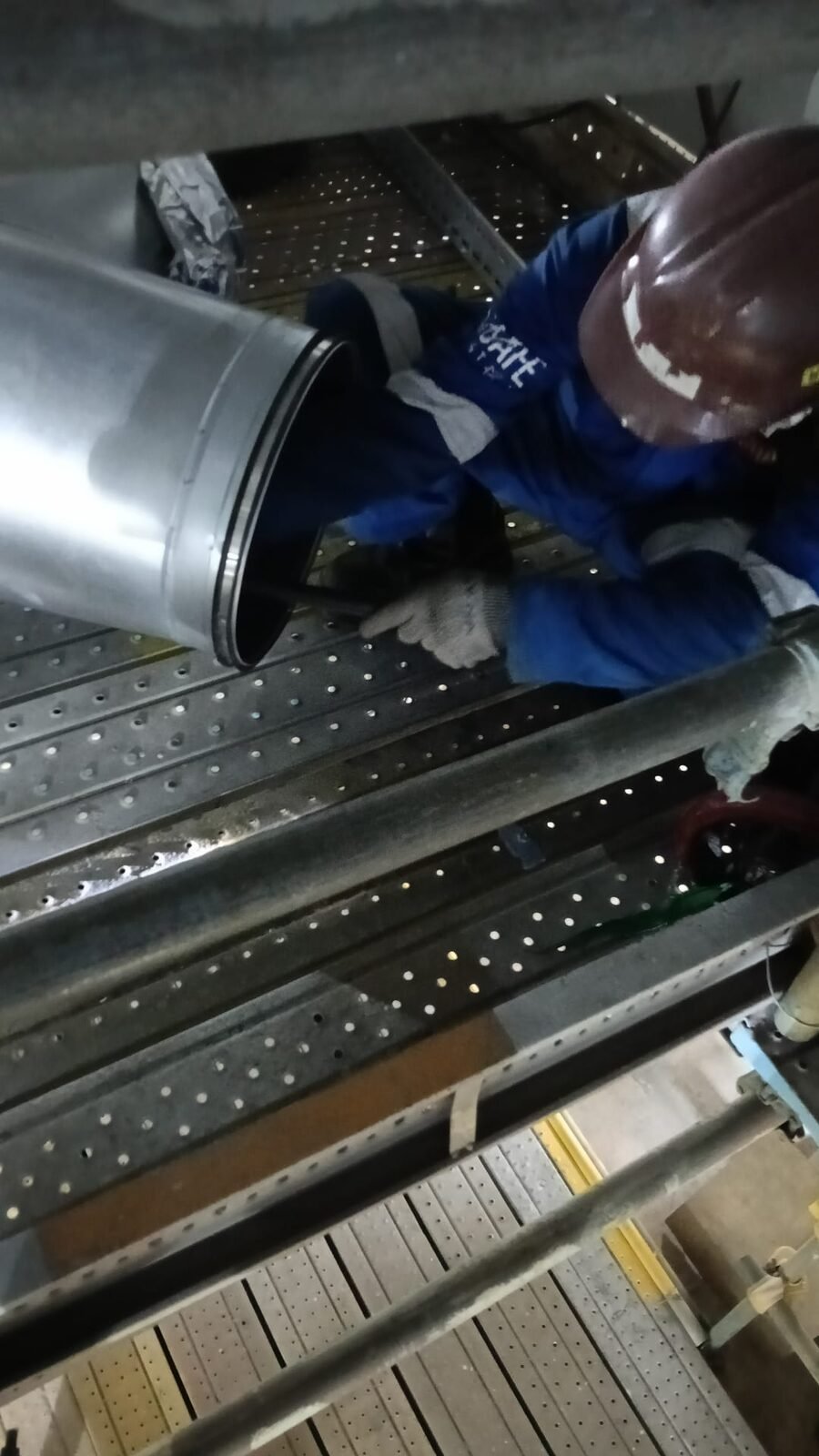 Fitter offering up a large-diameter spiral duct section at high level