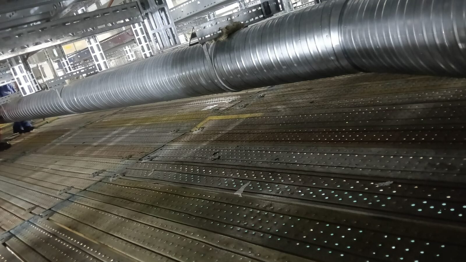 Large-diameter galvanised spiral duct main run installed at high level