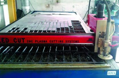 CNC plasma cutting table with a cut steel plate on the bed