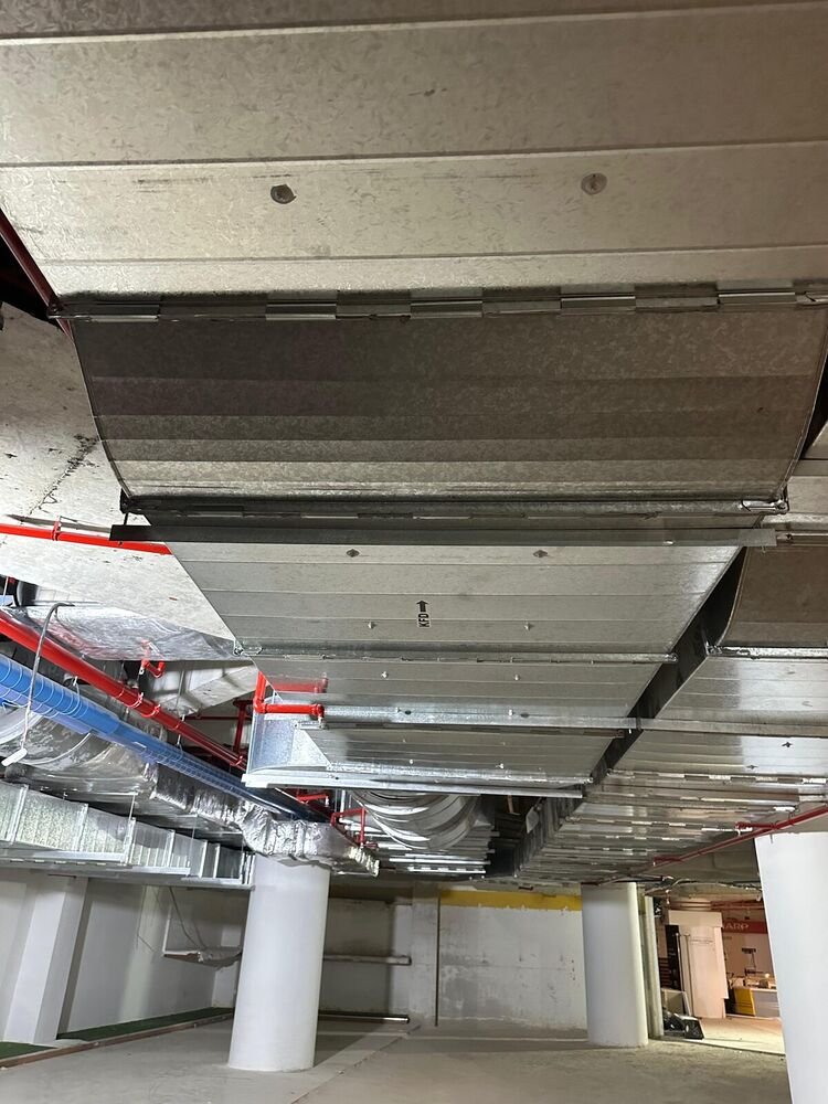 Car park ventilation duct main running the length of the slab