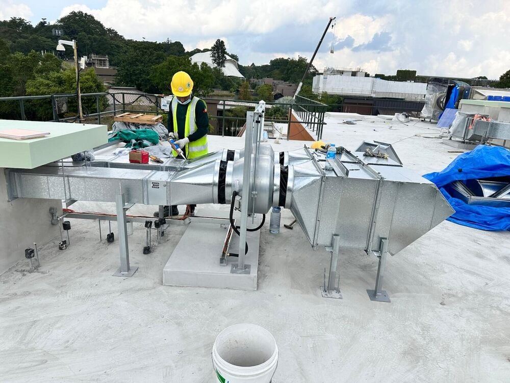Rooftop fan and ductwork being installed on plinths