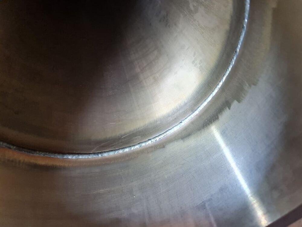 Internal root pass viewed through the bore of a stainless pipe after purge welding