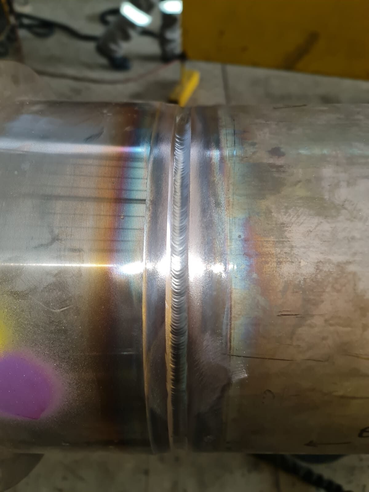 Completed circumferential weld on stainless pipe showing heat tint and bead profile