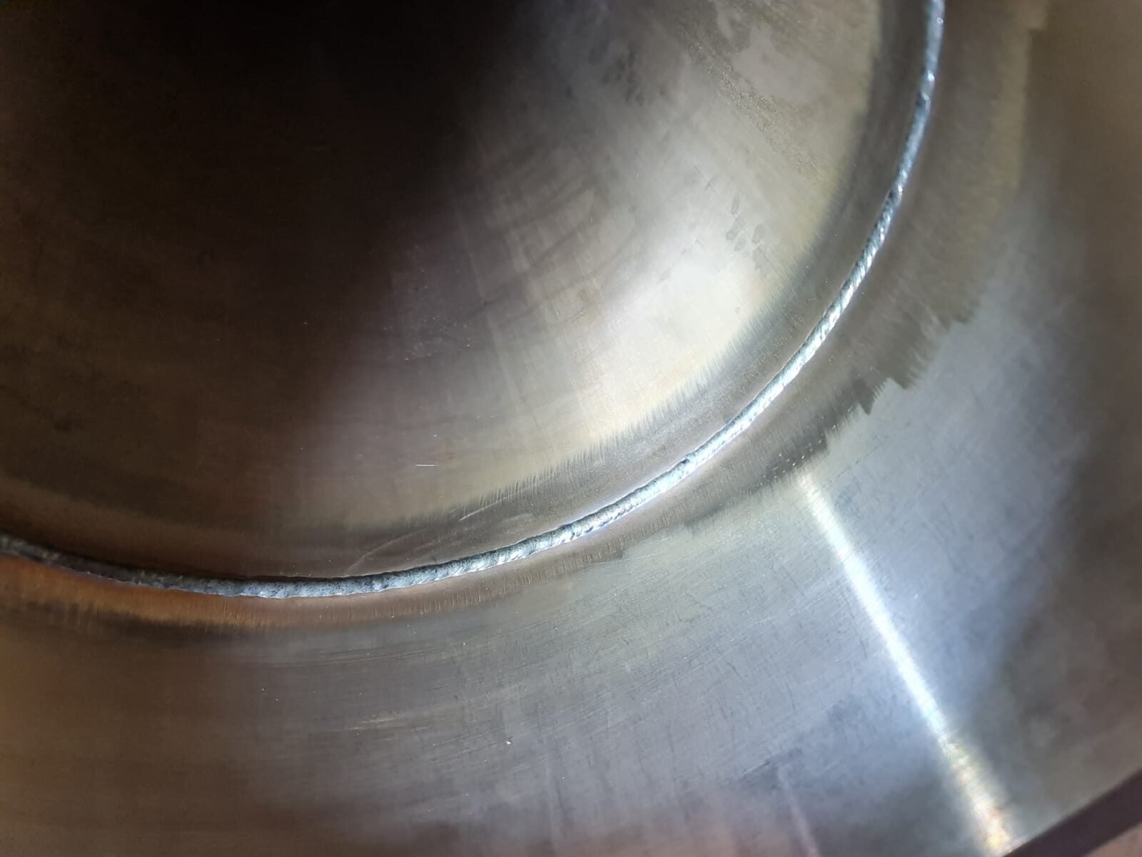 Internal root pass viewed through the bore of a stainless pipe after purge welding