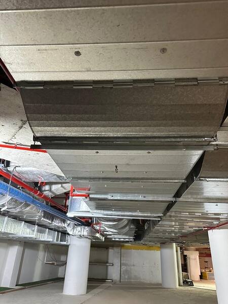 Car park ventilation duct main running the length of the slab