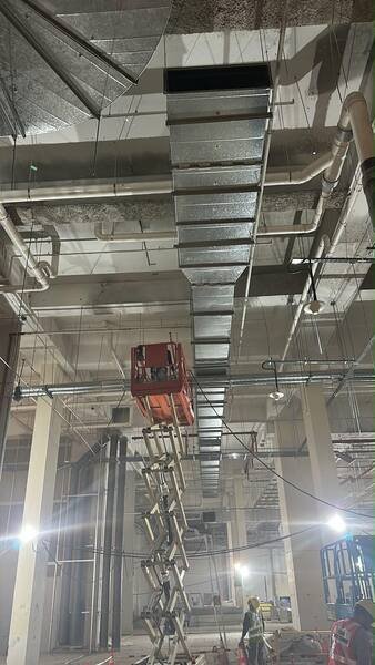 Duct installation in progress from a scissor lift
