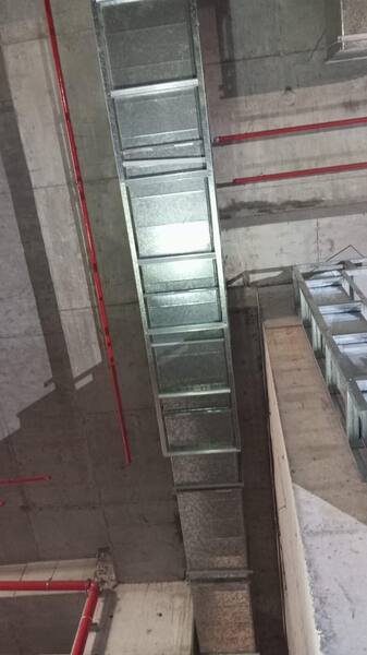 Duct riser turning into the ceiling void of a car park