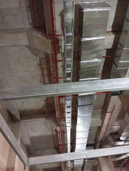 Galvanised duct run fixed to the soffit alongside services