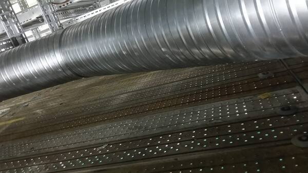 Spiral duct main run traced across the plant at high level