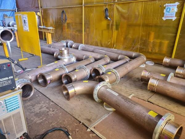 Flanged carbon steel spools laid out in a screened welding bay
