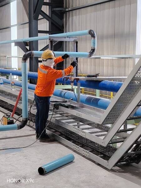 Pipe run installed alongside cable tray on a shared rack