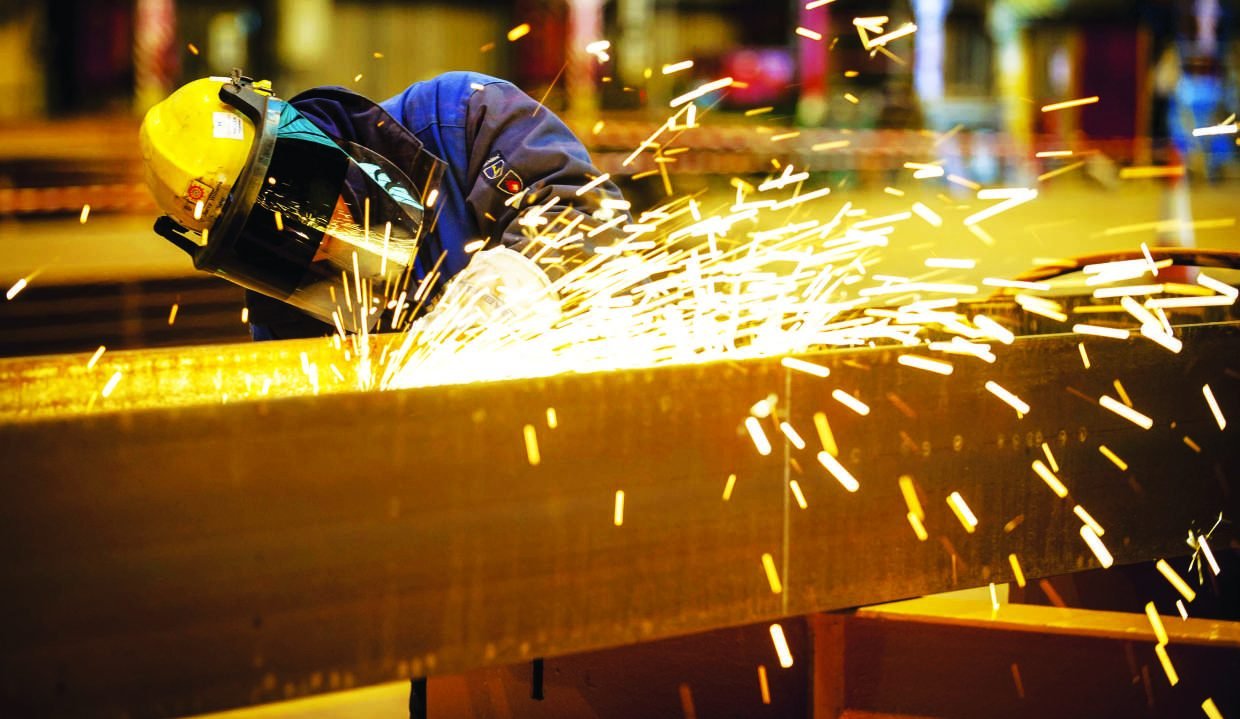 Welder grinding a steel beam with sparks flying
